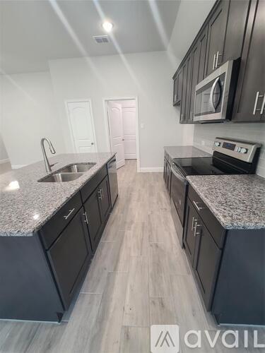 A kitchen with dark cabinets and granite countertops.