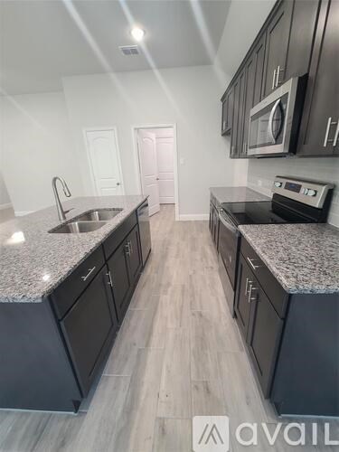 A kitchen with dark cabinets and granite countertops.