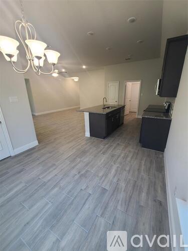 A spacious room with a grey floor and a television on the wall.