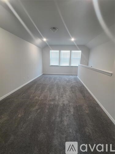 A room with a window and a carpeted floor.