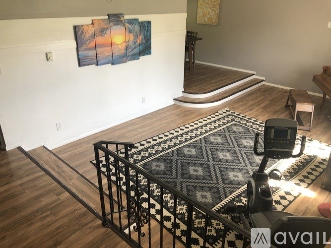A room with a large rug and a painting on the wall.