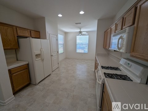 A kitchen with white appliances and wooden cabinets.