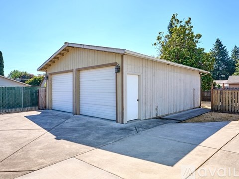 A two-car garage with a tan exterior and white doors is available for rent.