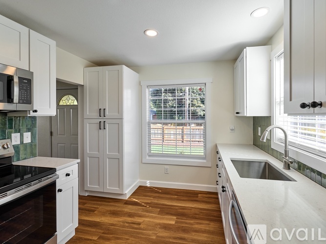 A kitchen with white cabinets and a black stove top oven.