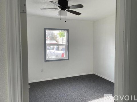 A room with a ceiling fan and a window.