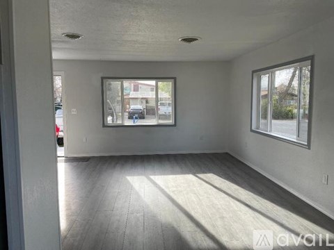 A room with a window and a door leading to a street.