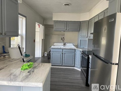 A kitchen with a marble countertop and stainless steel appliances.
