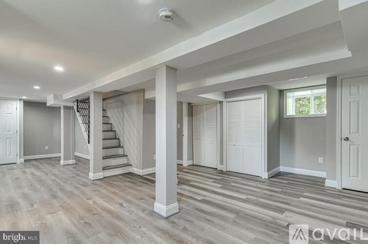 A spacious living room with a staircase leading to the upper level.
