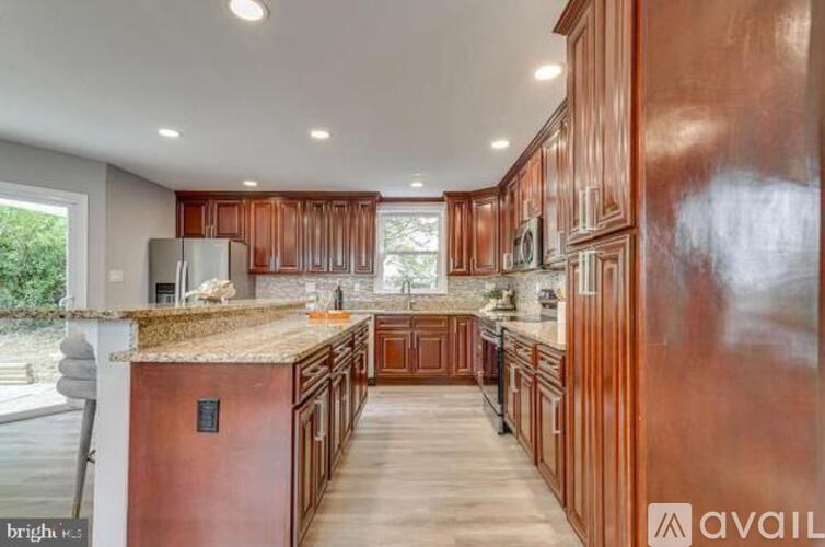 A kitchen with wooden cabinets and a granite countertop.