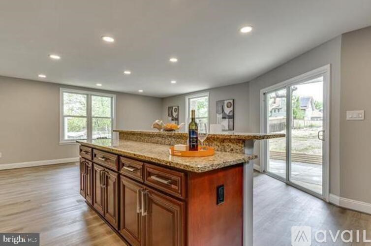 A kitchen with brown cabinets and a granite countertop.