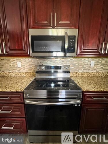 A kitchen with a stove top oven and microwave above it.