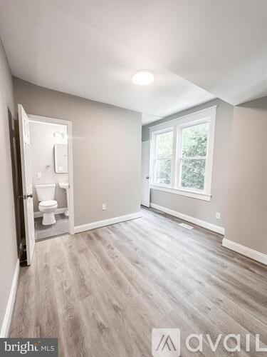 A room with a toilet and a window.