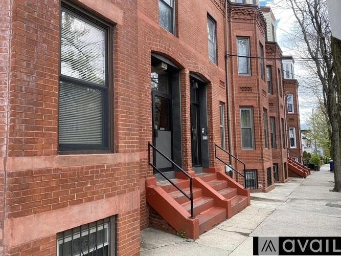 A red brick building with a black door and windows.