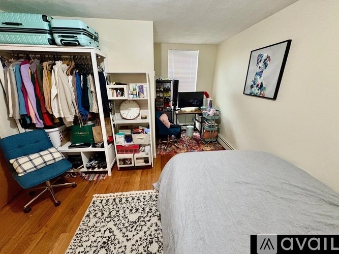 A bedroom with a bed, chair, and closet.