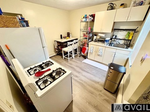 A small kitchen with a white gas stove and a white refrigerator.