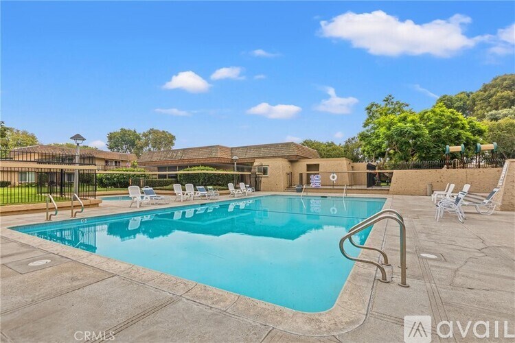 A large outdoor swimming pool surrounded by lounge chairs.