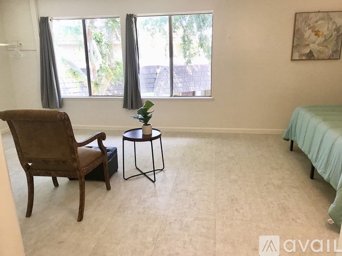 A room with a chair, a table, and a bed.