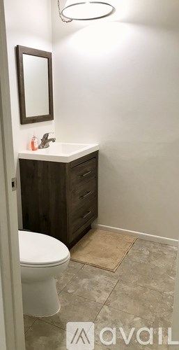Two grey chairs and a red table are on a patio.