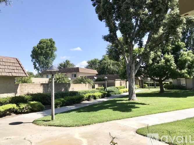 A residential area with houses, trees, and a clear sky.