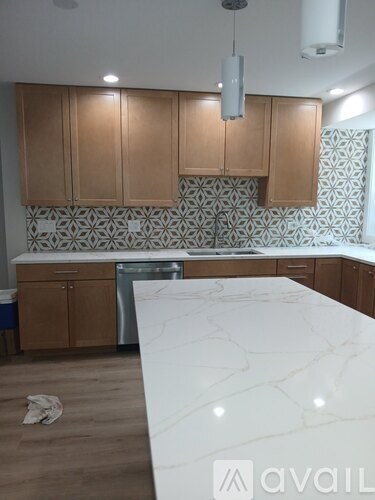 A kitchen with wooden cabinets and a marble countertop.