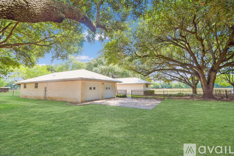 A house with a white roof is surrounded by trees.