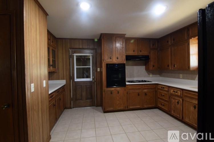 A kitchen with wooden cabinets and a black refrigerator.