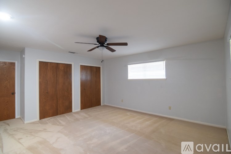 A room with a ceiling fan and two doors.