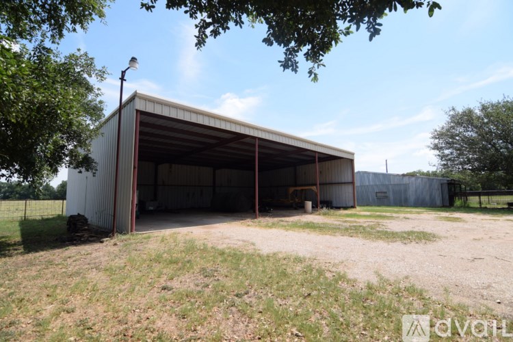 A large metal building with a dirt ground in front.