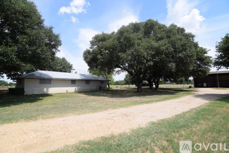 A farm scene with a barn, trees, and a dirt road.