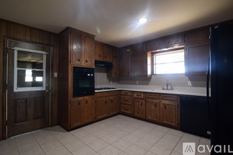 A kitchen with wooden cabinets and black appliances.