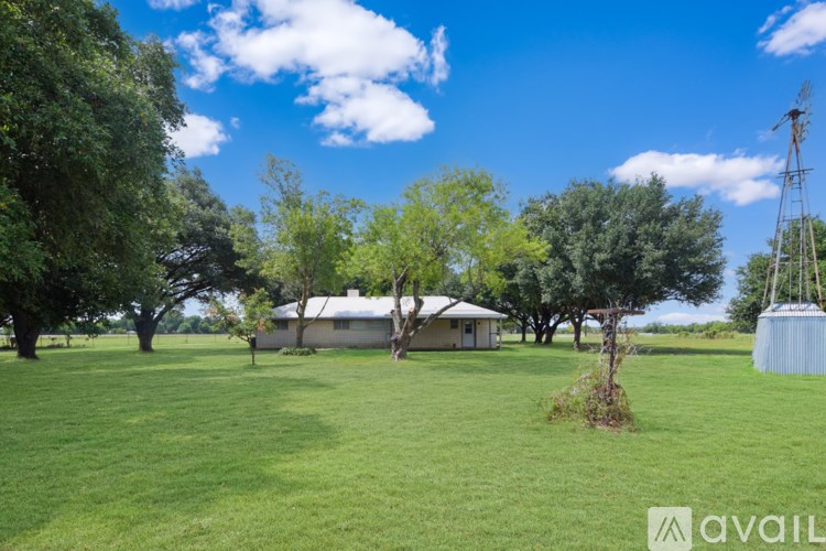 A spacious room with a fan and wooden flooring.