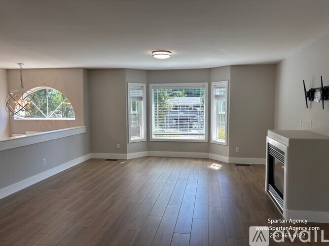 A spartan agency office with wood flooring and a large window.