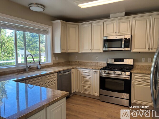 A kitchen with white cabinets and a black stove top oven.