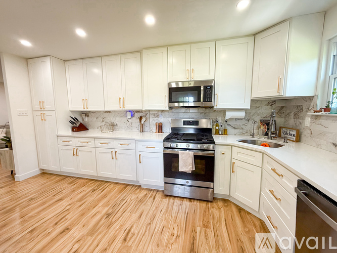 A kitchen with white cabinets and a wooden floor.
