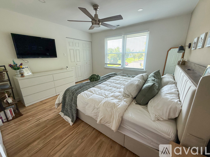 A bedroom with a large bed and a flat screen TV mounted on the wall.