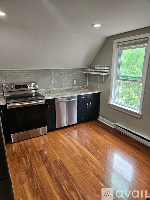 A kitchen with wood flooring and a window.