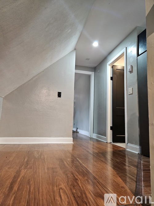 A hallway with wood floors and white walls.