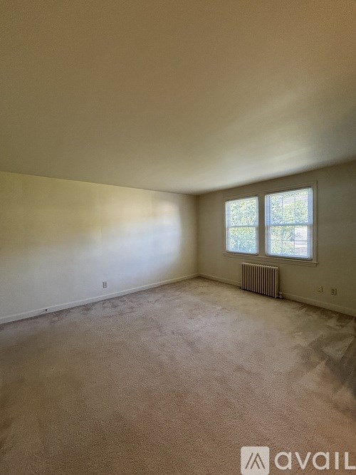A room with a window and a radiator on the floor.