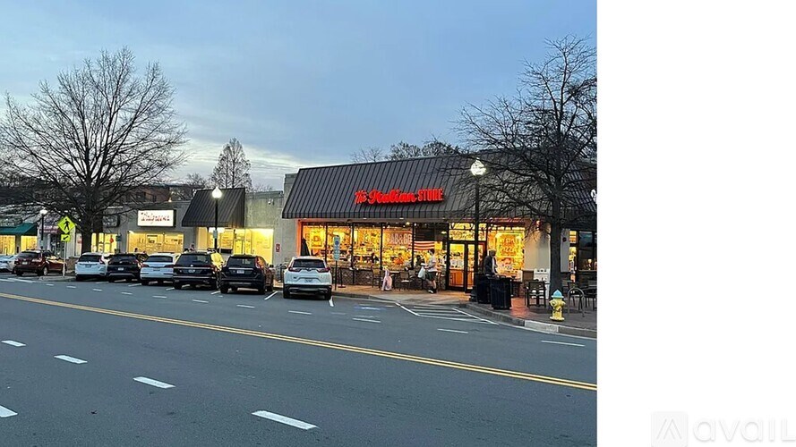 Cars are parked in front of a store with a red awning.