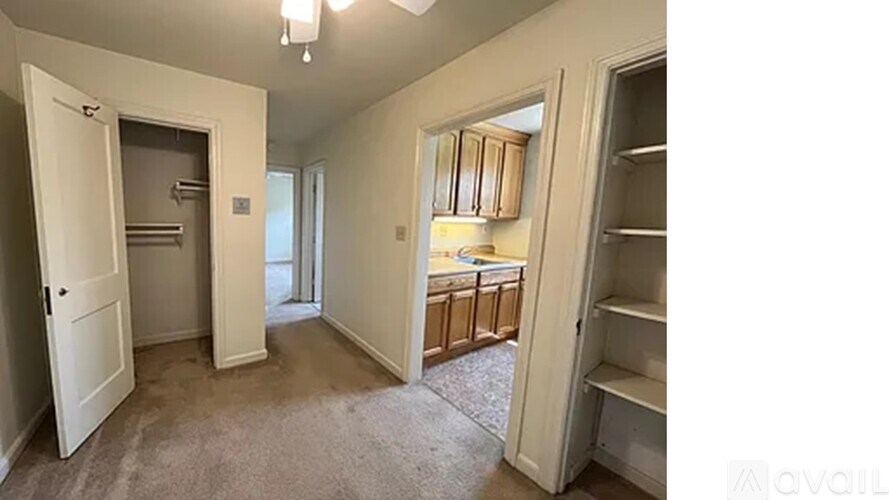 A room with a white door, a grey carpet, and a white cabinet.