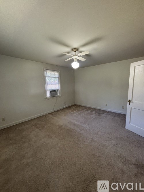 A room with a ceiling fan and a window.