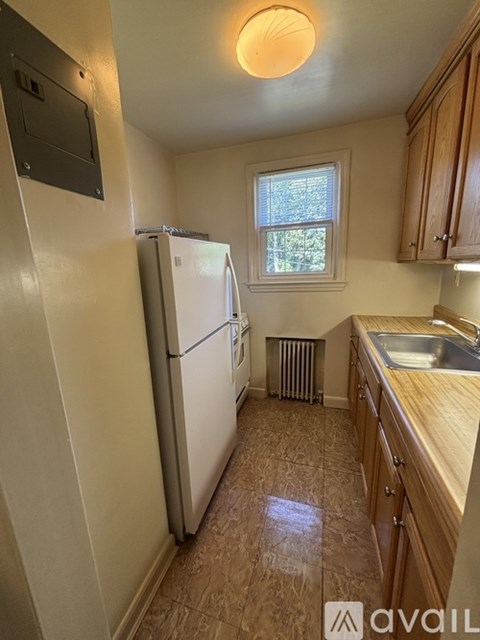 A kitchen with a white fridge and wooden cabinets.