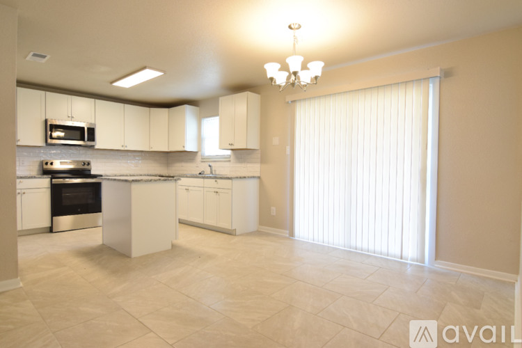 A kitchen with white cabinets and a tiled floor.