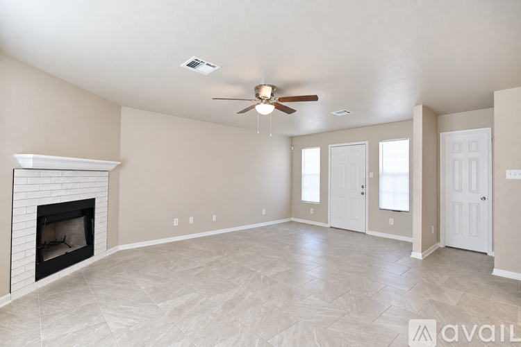A living room with a fireplace and a ceiling fan.