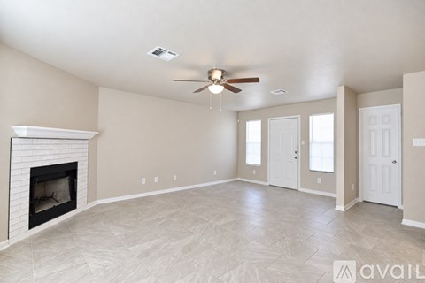 A living room with a fireplace and a ceiling fan.