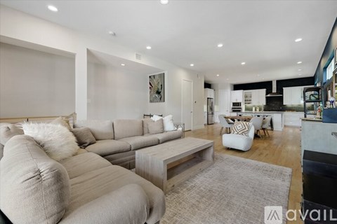 A modern living room with a grey sofa and a grey rug.