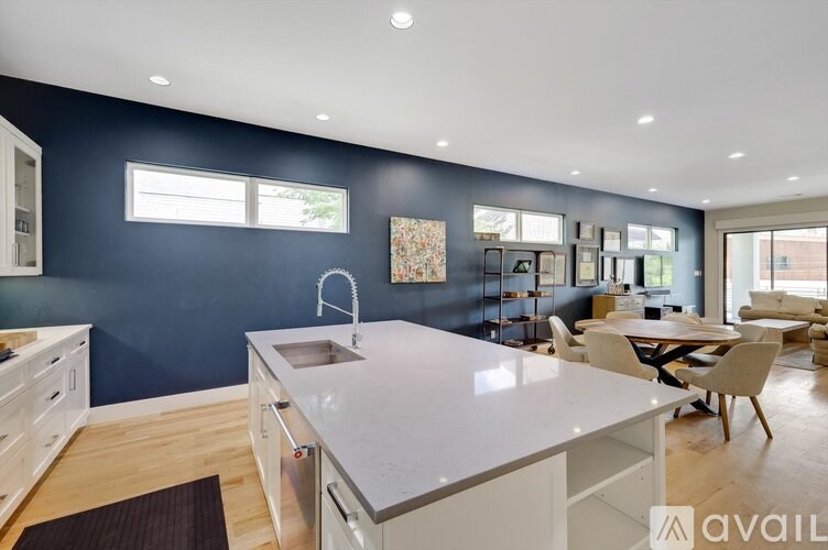 A modern kitchen with a large island and a dining area.