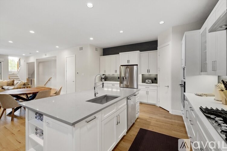 A modern kitchen with white cabinets and stainless steel appliances.