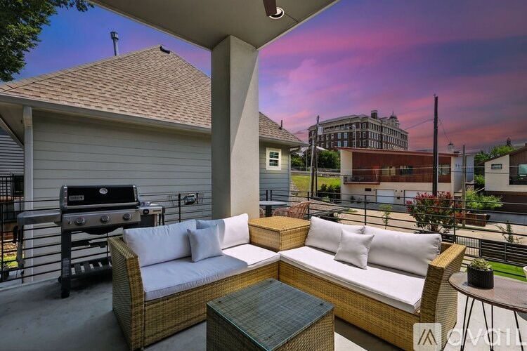 A patio with a couch, table, and grill.