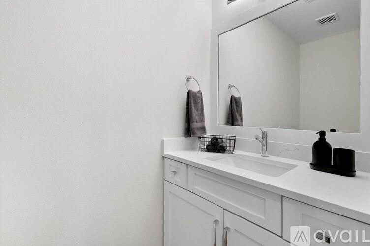 A bathroom with a white sink and a mirror.